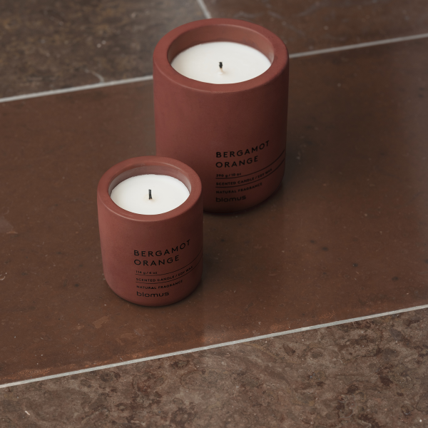 Two stylish bergamot orange candles on a marble surface, enhancing the elegant decor.