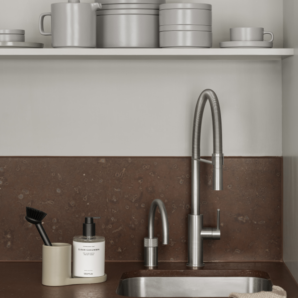 Modern kitchen with sleek faucet, elegant dishware, and stylish counter organization.