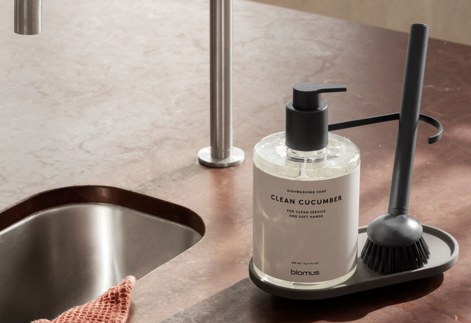 Dishwashing soap dispenser with clean cucumber scent on modern kitchen countertop.