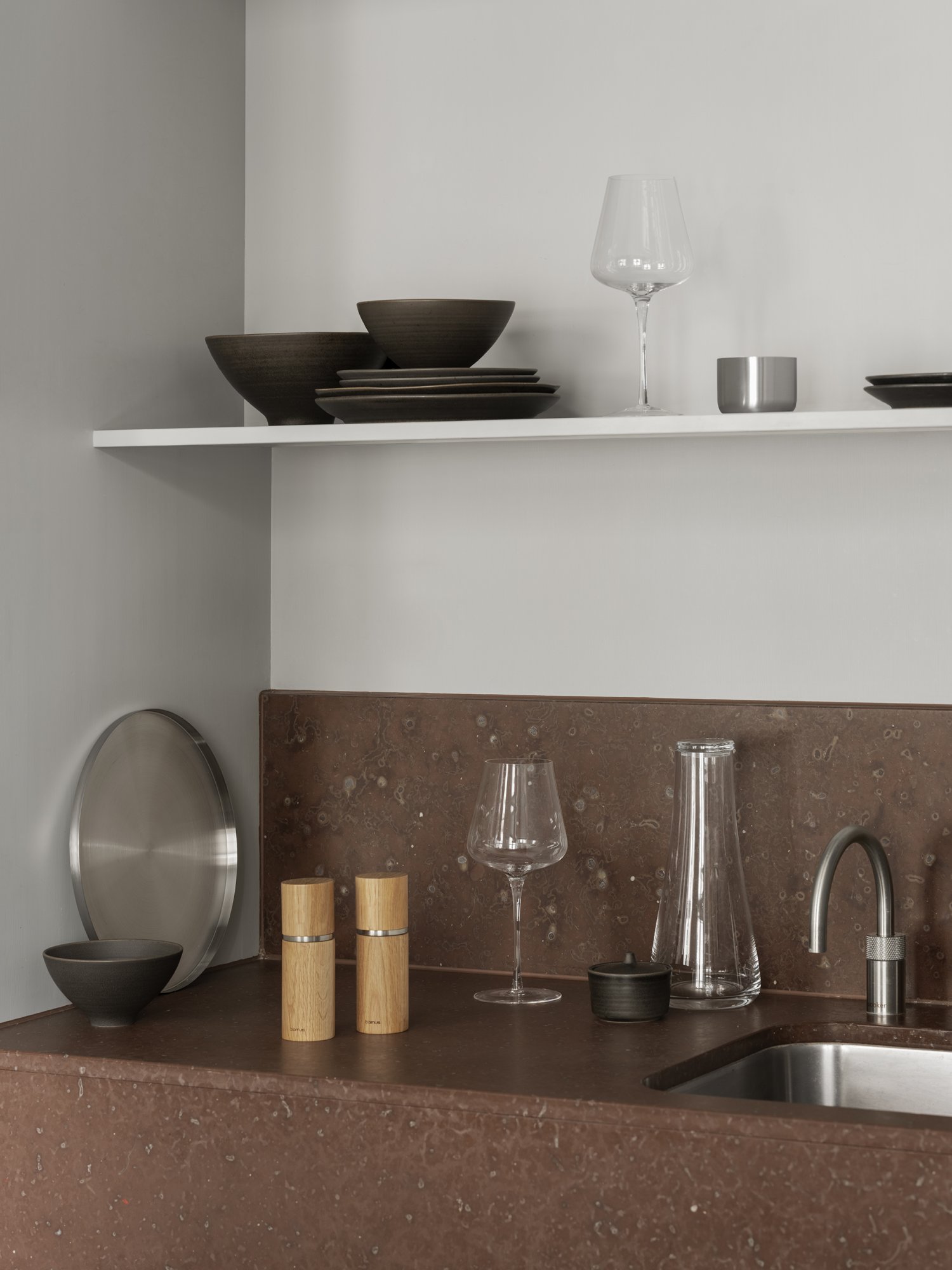 Modern kitchen decor featuring stylish glassware and elegant tableware on minimalist shelves.
