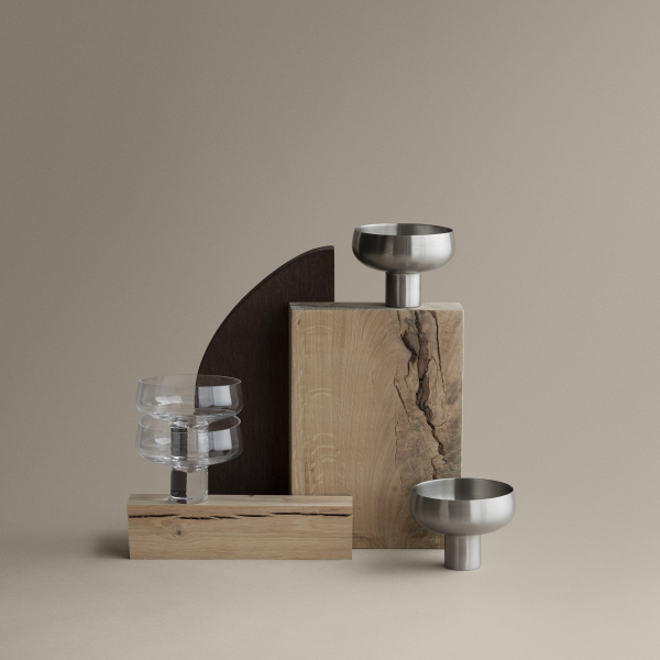 Artistic display of modern decor elements featuring wood and metal bowls on a neutral background.