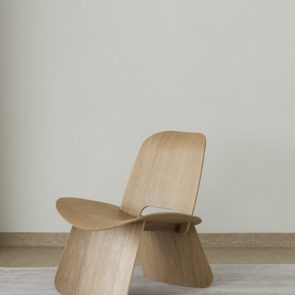 Minimalistischer Holzstuhl vor einer hellen Wand, der modernes Design und Handwerkskunst präsentiert.