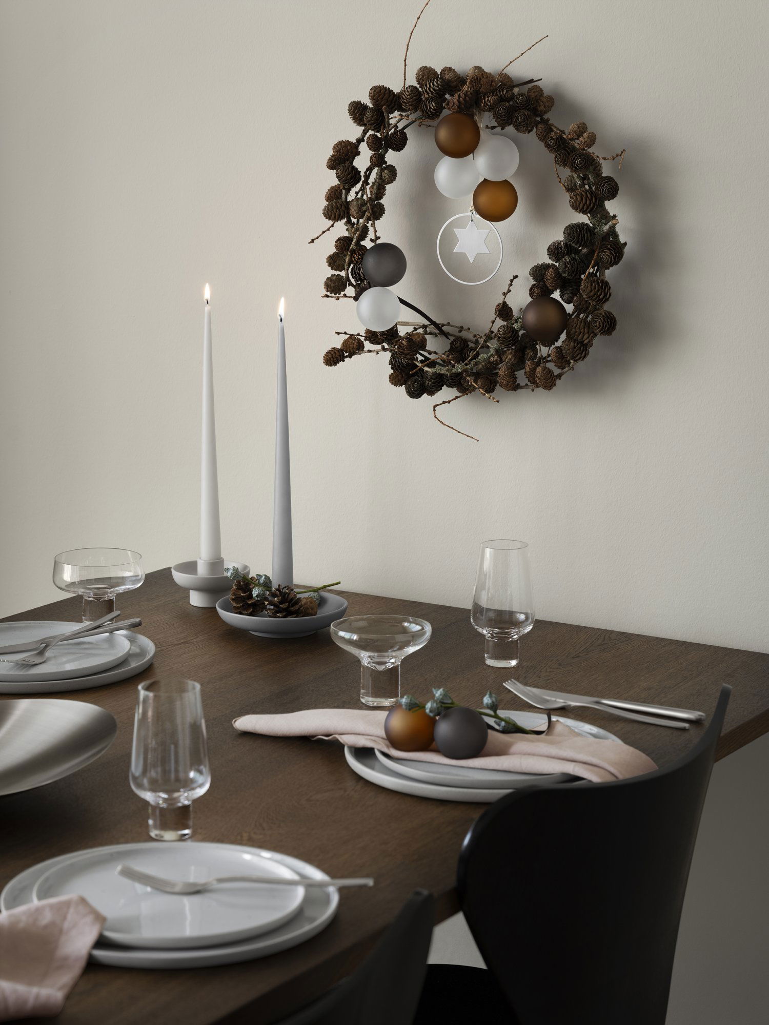 Elegantes Esszimmer-Set für einen festlichen Anlass mit Kerzen und einem Kiefernnadelkranz.