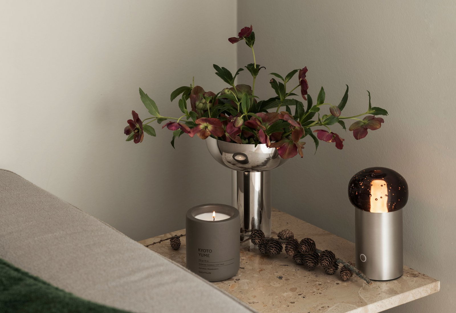 Stylish tabletop arrangement with a floral centerpiece and a lit scented candle.