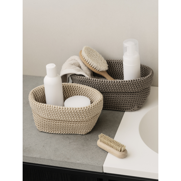 Stylish woven storage baskets with toiletries and brushes on a countertop.