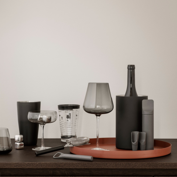 Elegante moderne Tischdekoration mit Gläsern, Flaschen und Zubehör auf einem stilvollen Tablett.
