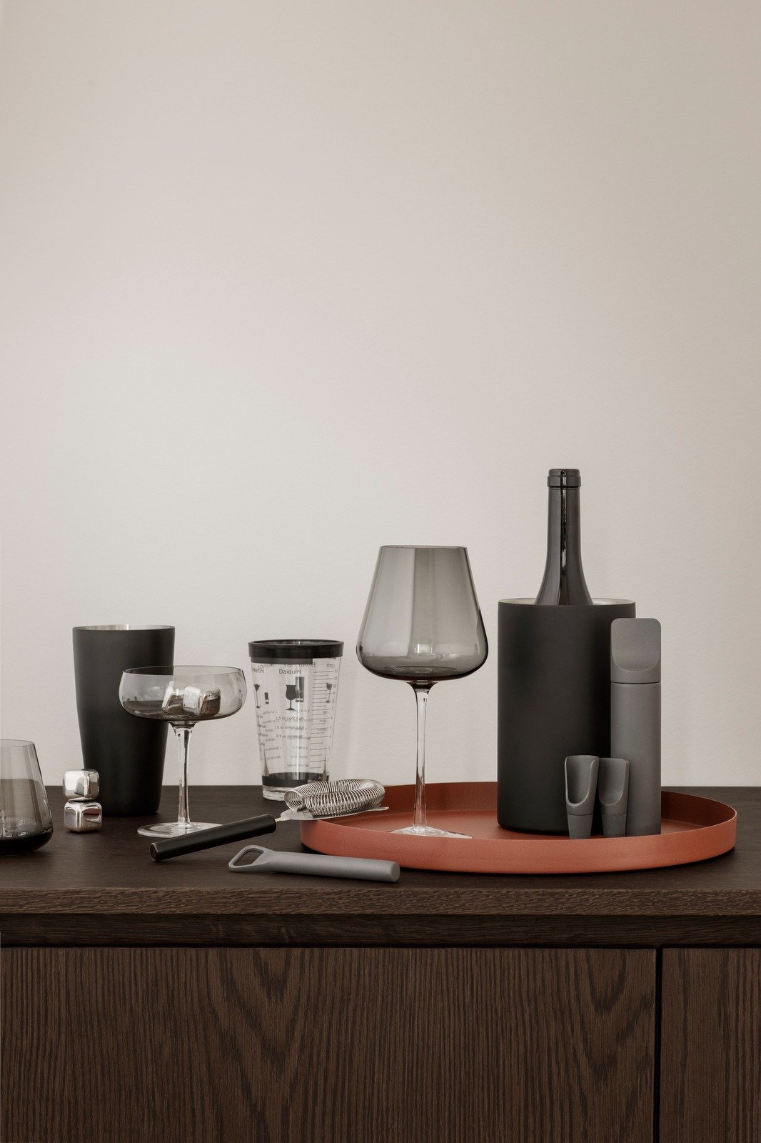 Elegante moderne Tischdekoration mit Gläsern, Flaschen und Zubehör auf einem stilvollen Tablett.