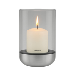 Modern glass candle holder with a white pillar candle and a sleek metal base.