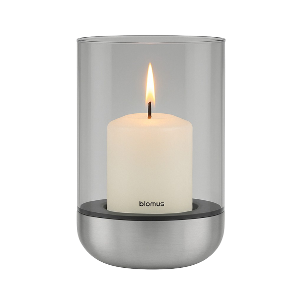 Modern glass candle holder with a white pillar candle and a sleek metal base.