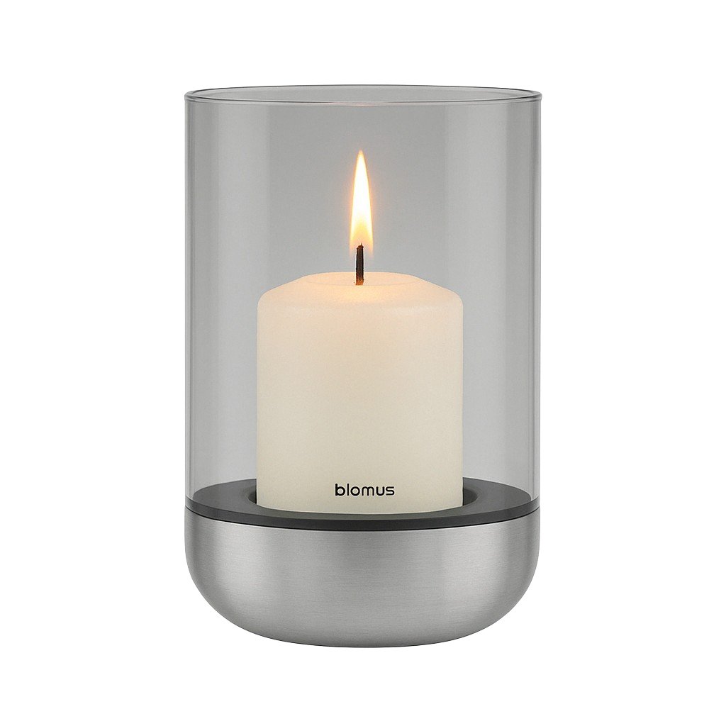 Modern glass candle holder with a white pillar candle and a sleek metal base.