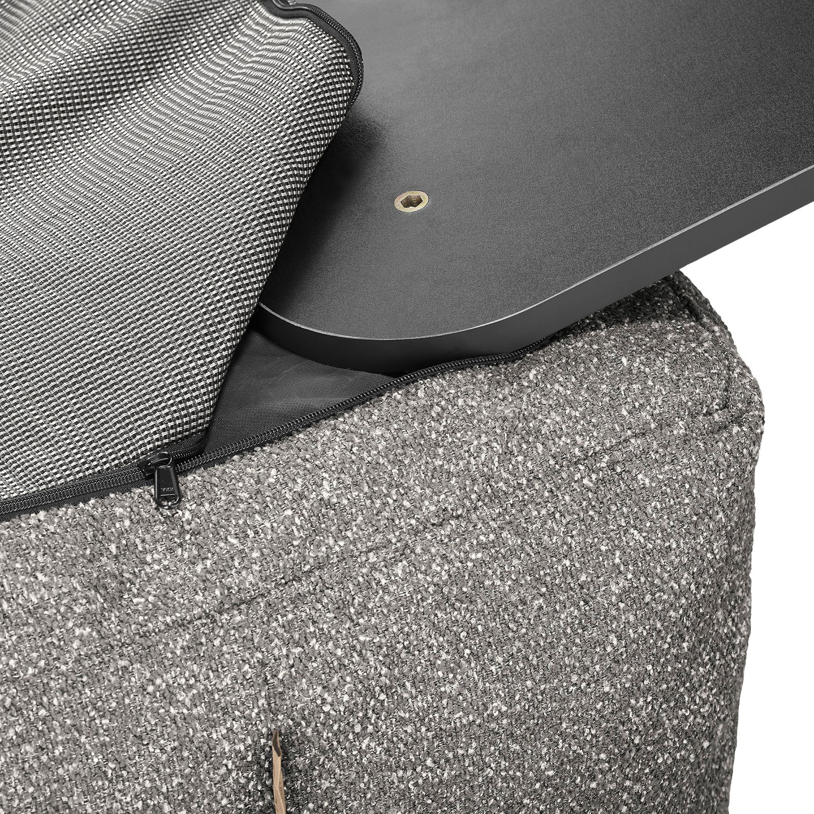 Close-up of a textured gray ottoman with a removable black top and zipper detail.