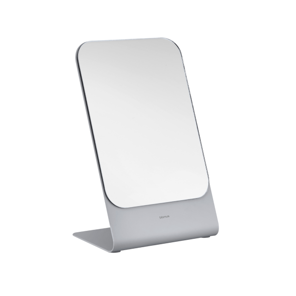 Eleganter moderner Tischspiegel mit minimalistischem Design und robustem grauen Fuß.