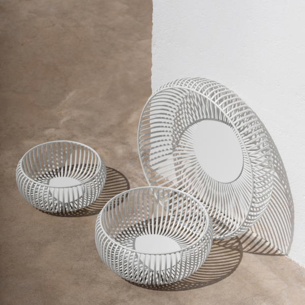 Stylish white wire baskets arranged on a minimalist concrete surface.