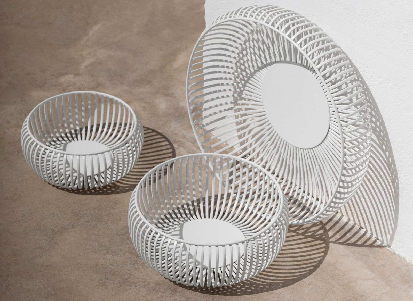 Modern white wire baskets set on a textured surface for stylish home decor.