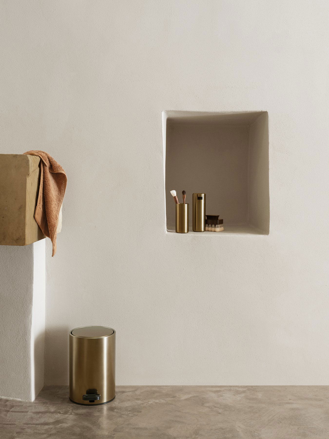 Eleganter Badezimmerbereich mit minimalistischem Stauraum und schicken goldenen Accessoires.