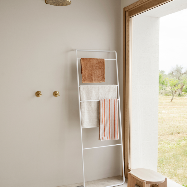 Modernes Badezimmer mit einem minimalistischen Handtuchhalter und natürlichem Licht, das durch ein Fenster strömt.