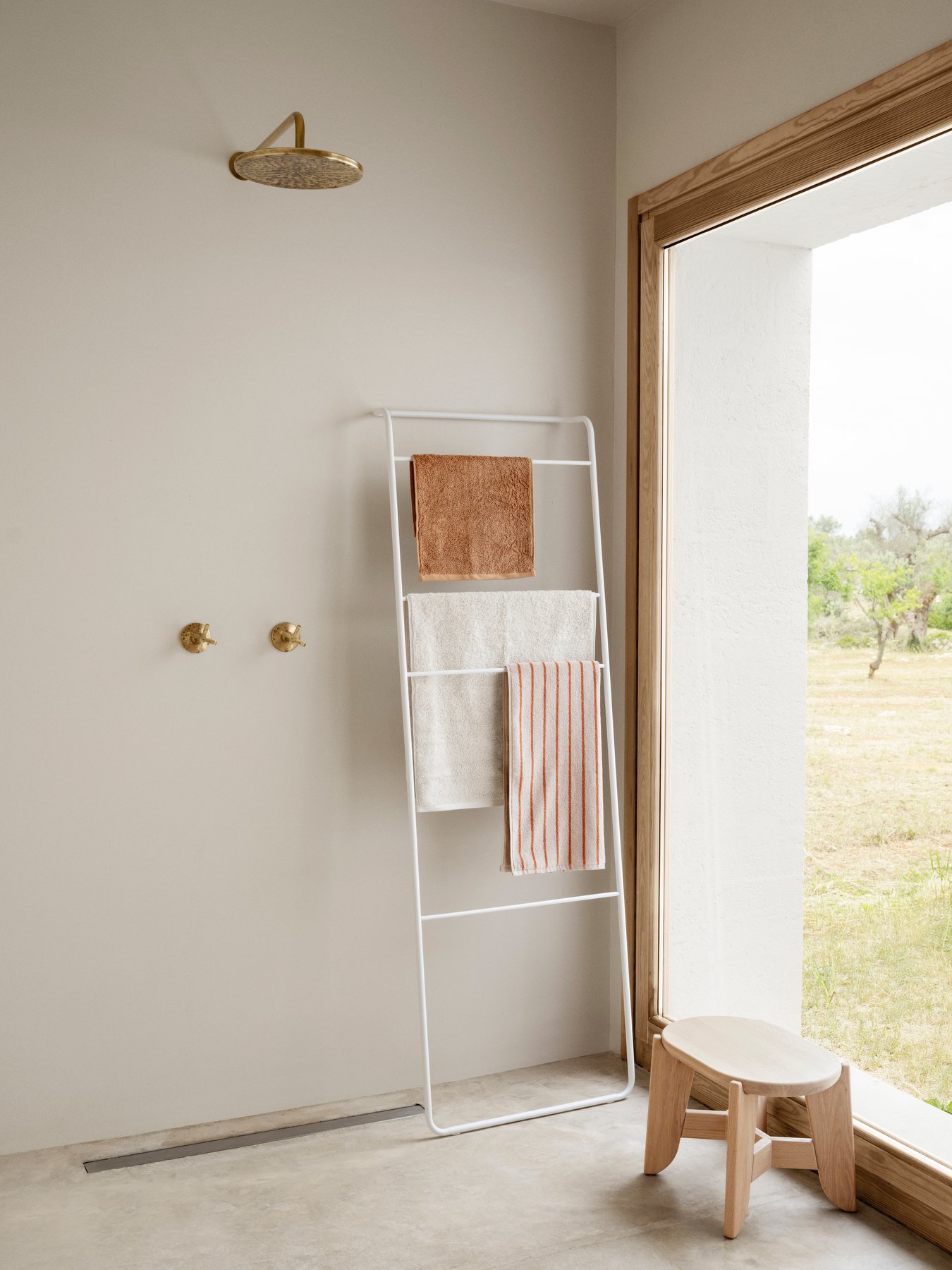 Modernes Badezimmer mit einem minimalistischen Handtuchhalter und natürlichem Licht, das durch ein Fenster strömt.