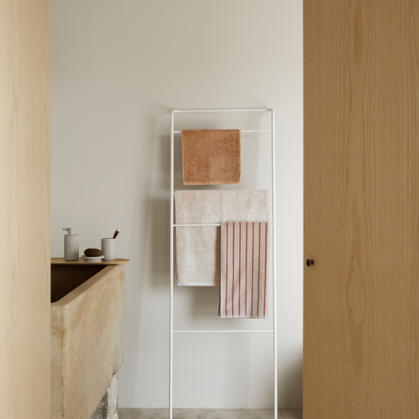 Moderner Badezimmer mit weißem Handtuchhalter, der ordentlich gefaltete Handtücher präsentiert.