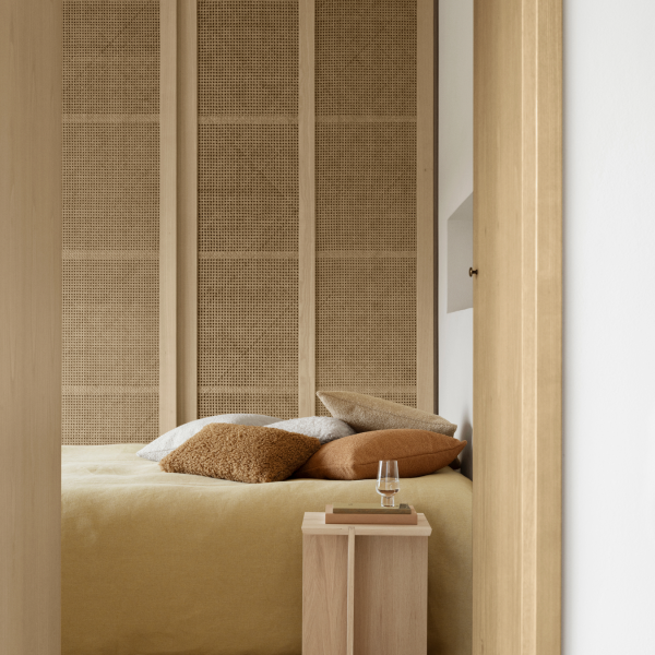 Modernes Schlafzimmer mit strukturierten Wänden, gemütlicher Bettwäsche und minimalistischer Einrichtung.