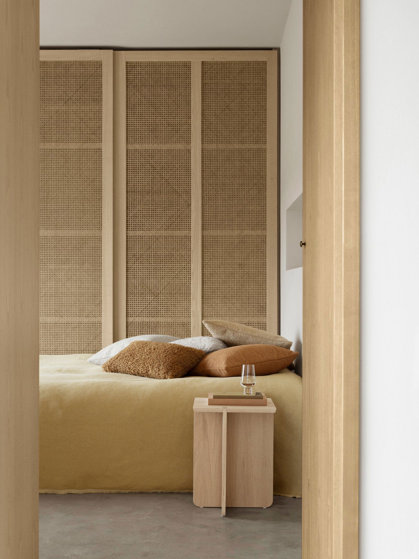 Modernes Schlafzimmer mit strukturierten Wänden, gemütlicher Bettwäsche und minimalistischer Einrichtung.