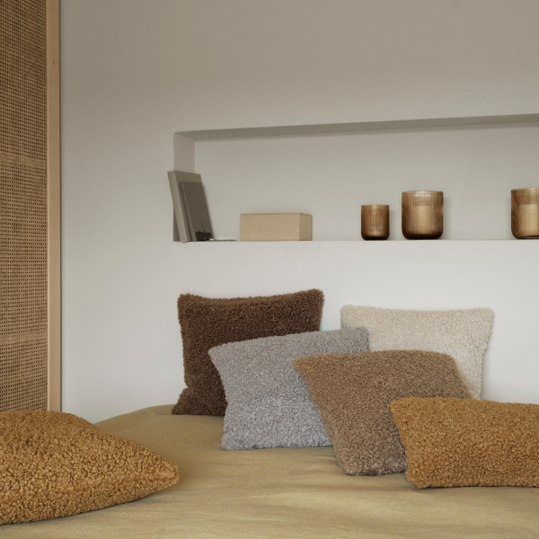 Gemütliches Schlafzimmer mit strukturierten Kissen in warmen Erdtönen und minimalistischem Dekor.