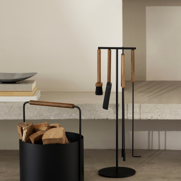 Stylish black metal fireplace tool set with wooden handles and a wood storage container.