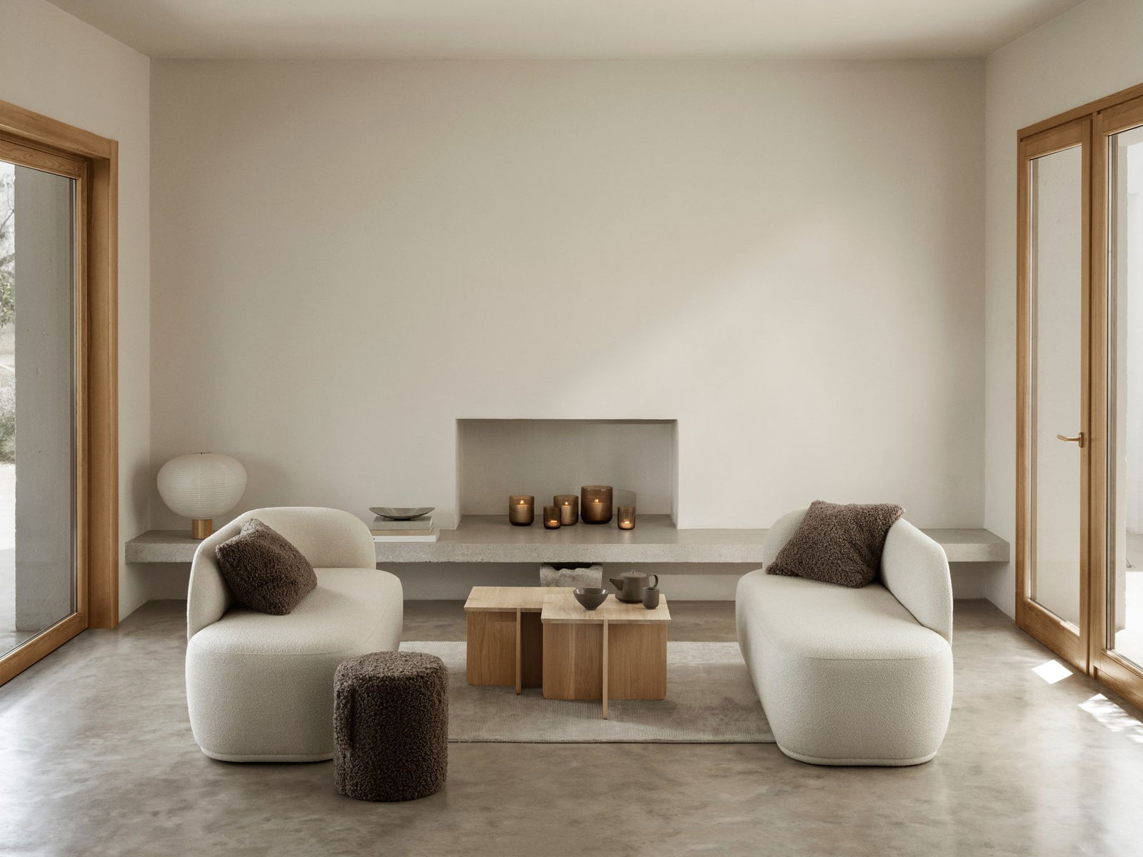 Moderner Wohnraum mit gemütlichen Sitzmöglichkeiten und minimalistischer Dekoration, die einen Holztisch umfasst.