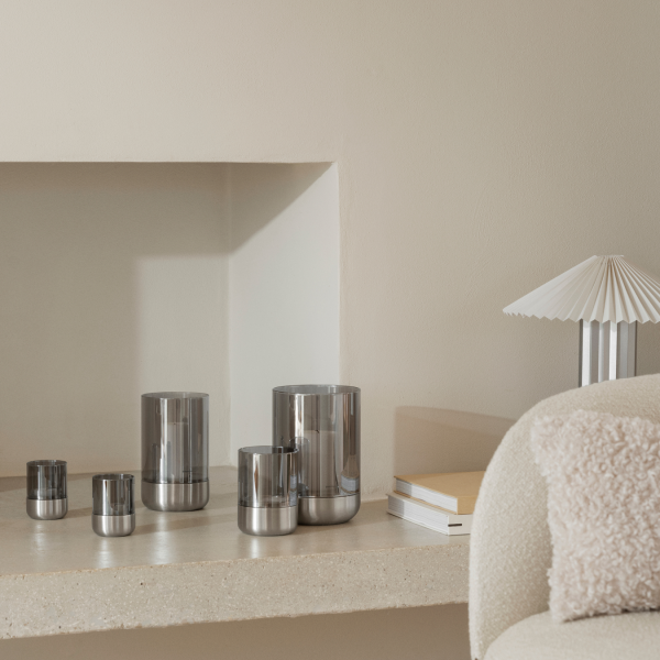 Moderne metallische Dekorationsgegenstände auf einem minimalistischen Regal in einem stilvollen Wohnraum angeordnet.