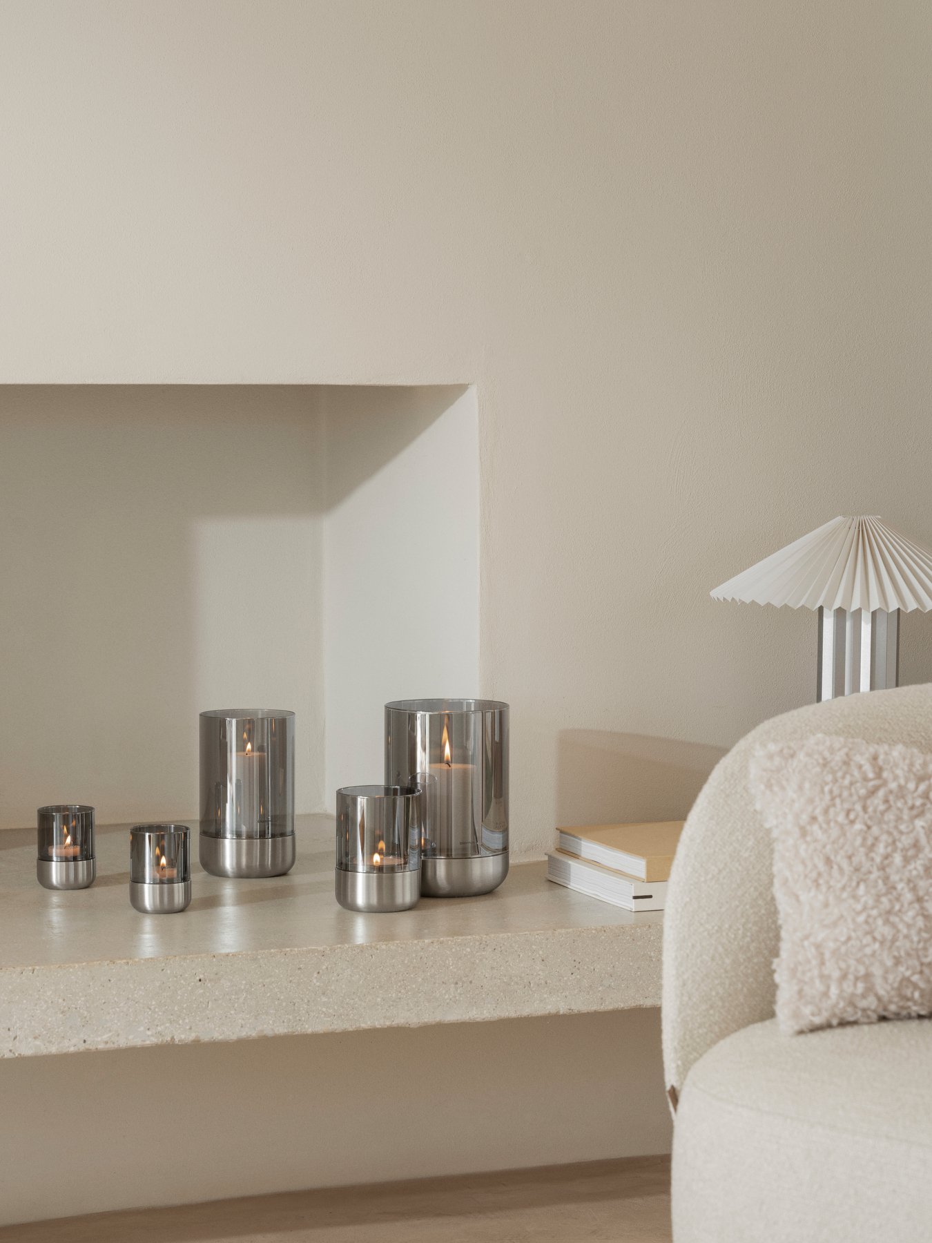 Elegante Kerzen auf einem minimalistischen Regal, die Wärme in einen modernen Wohnraum bringen.