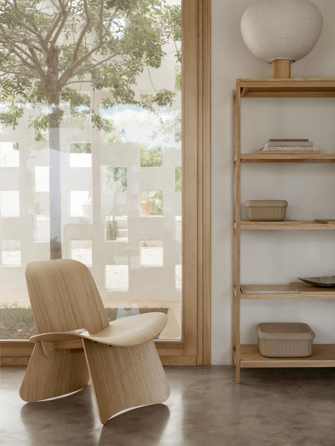 Moderne Holztisch und Regale in einem hellen, minimalistischen Innenraum mit natürlichem Licht.