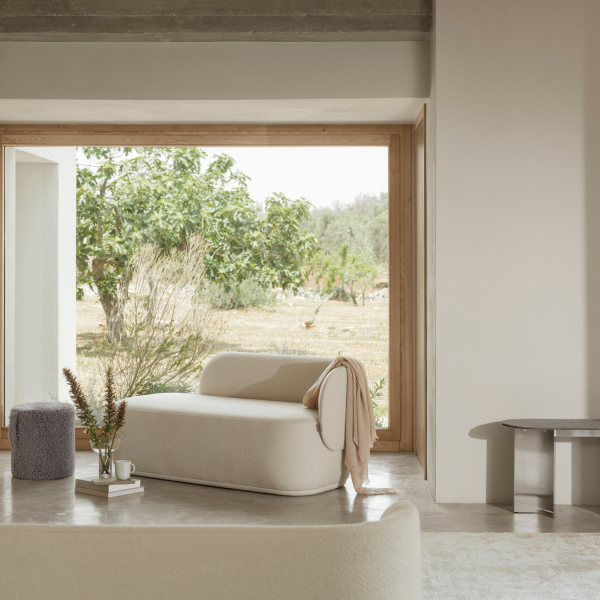 Gemütliches modernes Wohnzimmer mit stilvollen Möbeln und einem Blick auf die Natur draußen vor dem Fenster.
