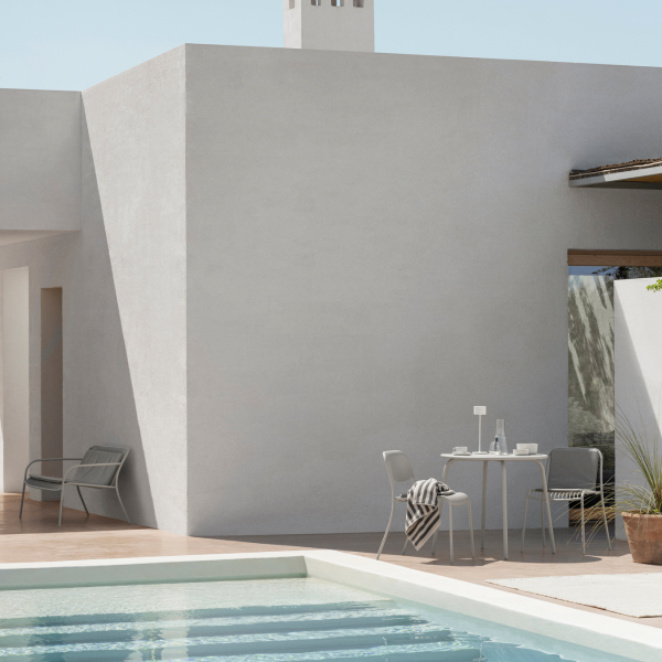 Moderne Außenspeisearea mit minimalistischer Gestaltung neben einem erfrischenden Pool.