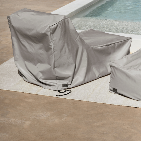 Stylish gray outdoor lounge chairs by a pool for relaxing and enjoying the sun.