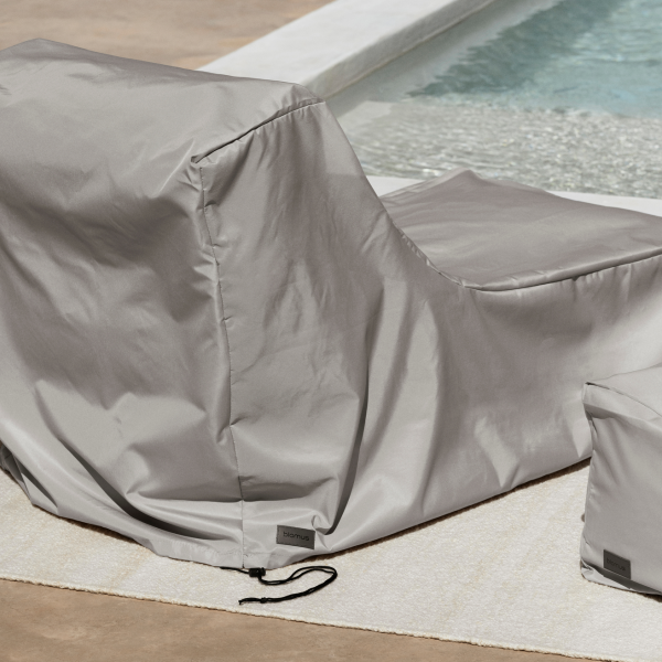 Stylish gray outdoor furniture cover by a swimming pool for weather protection.