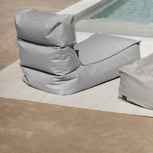 Stylish gray outdoor bean bag chair near a swimming pool.