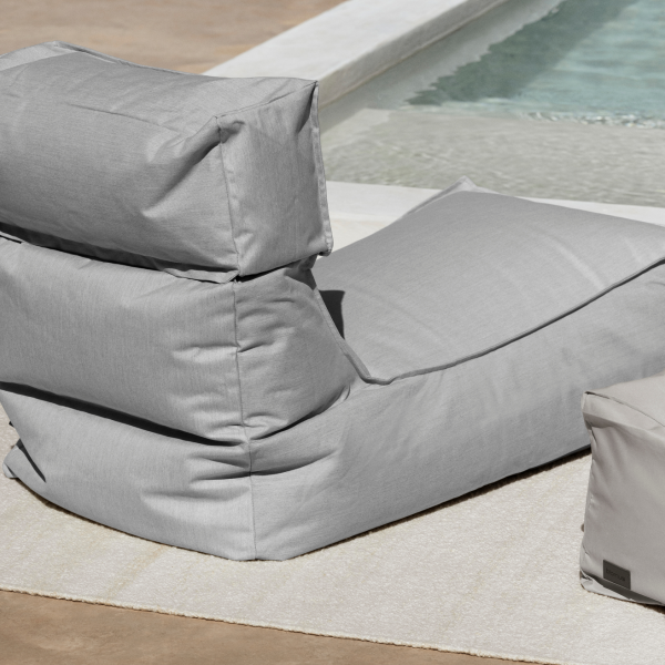 Cozy light gray beanbag chair by a swimming pool on a sunny day.