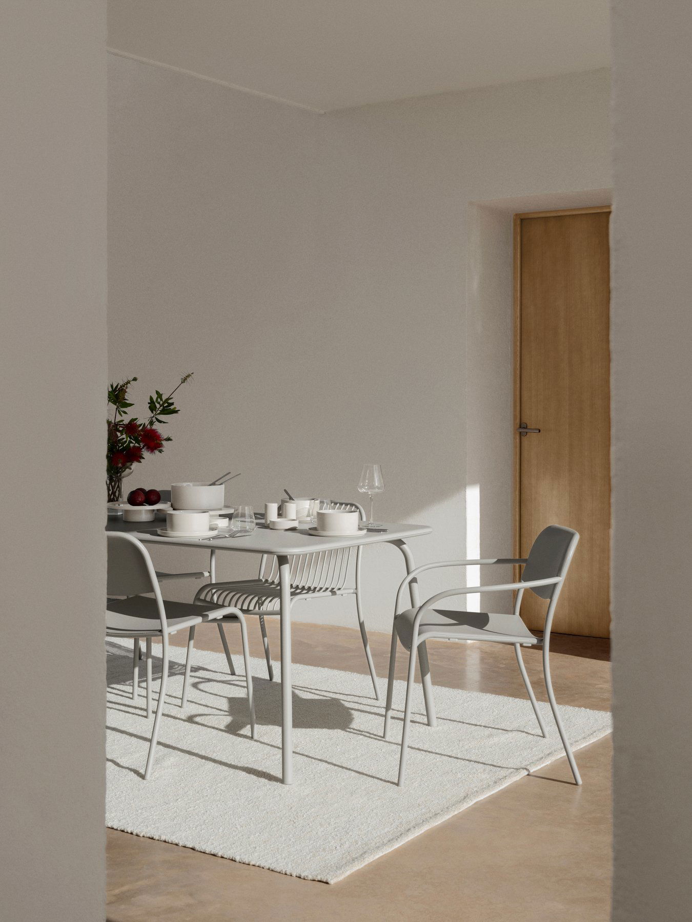 Modernes Esszimmer mit einem stilvollen Tischset, das minimalistisches Dekor und natürliches Licht bietet.