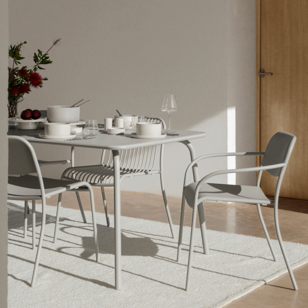 Modernes Esstischset mit eleganten Geschirr und frischen Blumen in einem hellen Raum.