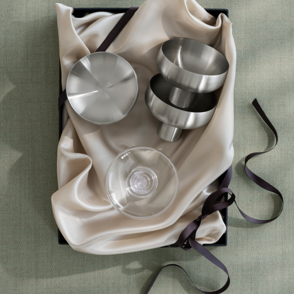 Stilvolle metallische Küchenwerkzeuge schön auf eleganter Stoff in einer Geschenkbox arrangiert.