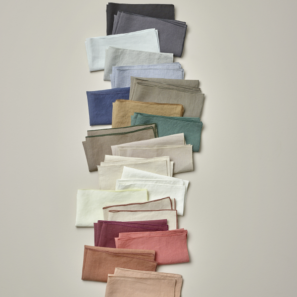 A vibrant display of neatly folded fabrics in various colors on a neutral background.