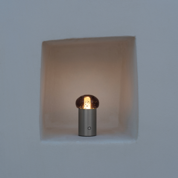 Moderne metallische Lampe, die eine ausgehöhlte Nische in einer weißen Wand beleuchtet.