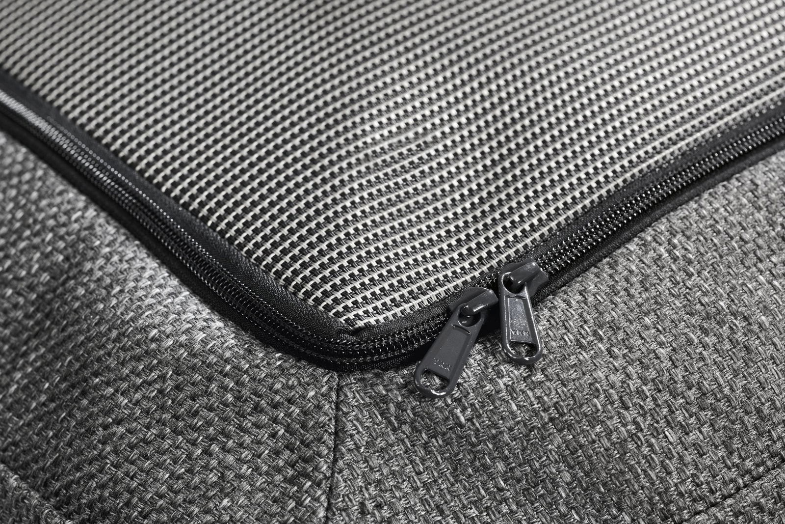 Nahaufnahme eines strukturierten schwarzen Stoffreißverschlusses an einer stilvollen Tasche oder einem Kissenbezug.