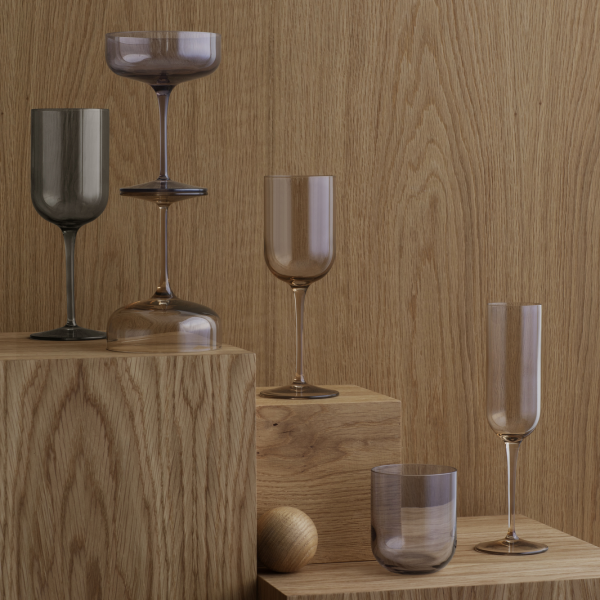 Stylische Gläser auf Holzblöcken gegen einen strukturierten Hintergrund angeordnet.