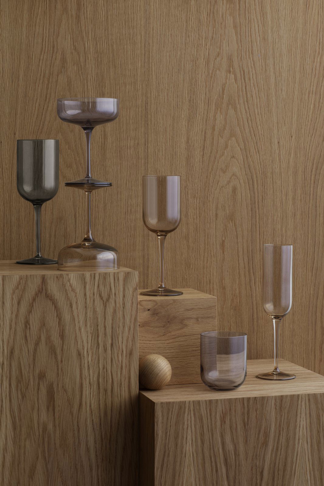 Stylische Gläser auf Holzblöcken gegen einen strukturierten Hintergrund angeordnet.