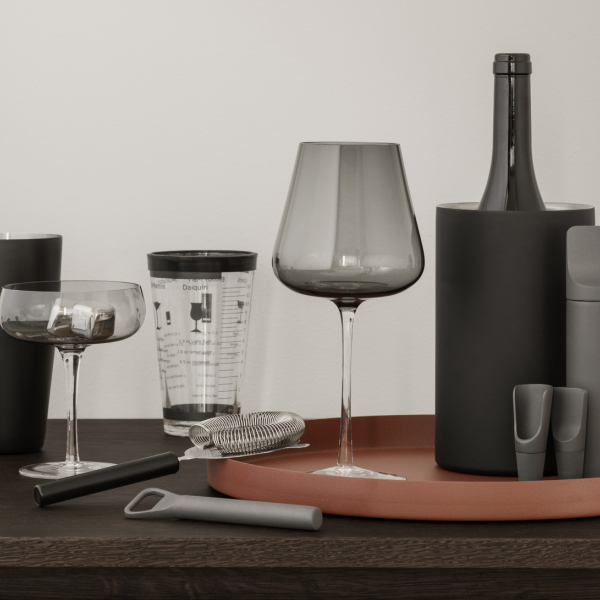 Moderne Küchenutensilien und elegante Gläser auf einer stilvollen Holzarbeitsplatte angeordnet.