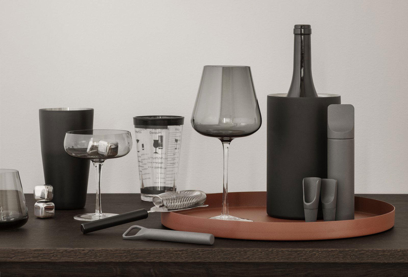Moderne Küchenutensilien und elegante Gläser auf einer stilvollen Holzarbeitsplatte angeordnet.