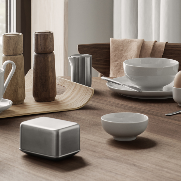 Elegant dining table set with minimalist tableware and wooden accents.