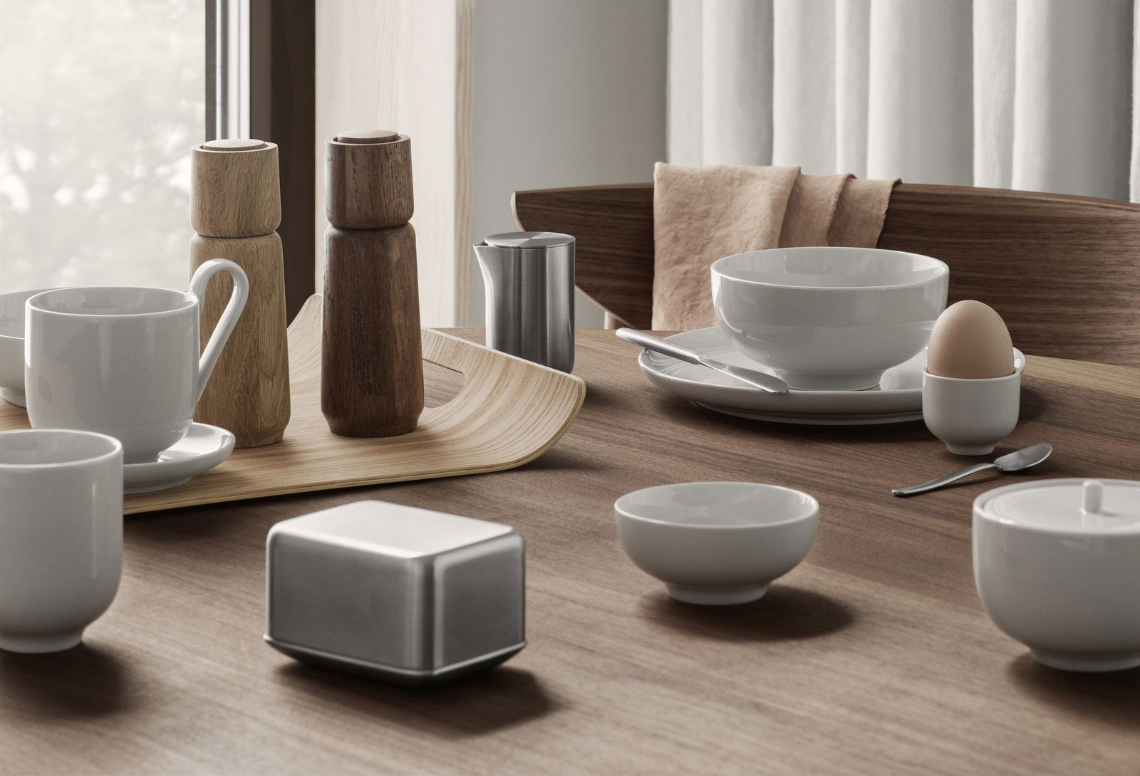 Elegant dining table set with minimalist tableware and wooden accents.