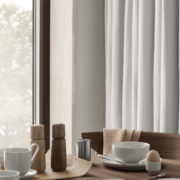 Elegant breakfast setting featuring minimalistic tableware by a window.