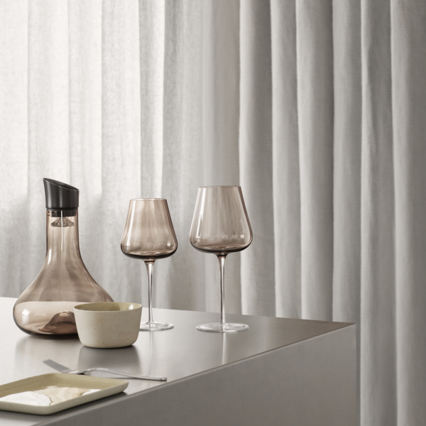 Elegantes Essens Arrangement mit rauchigen Glaskelchen und einer stilvollen Karaffe.